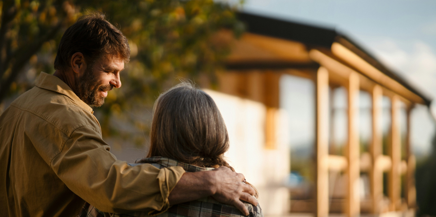 Couple Hugging and Looking at New Home