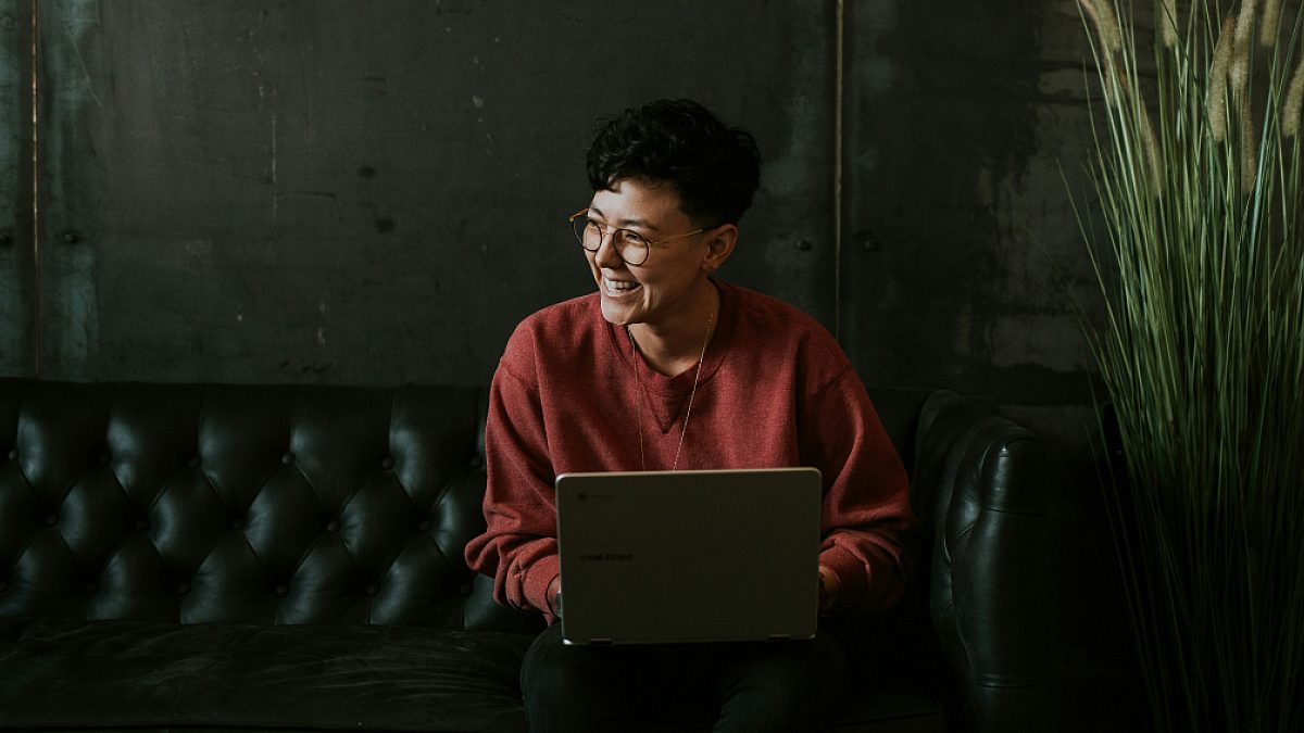 Young lady typing on laptop and smiling