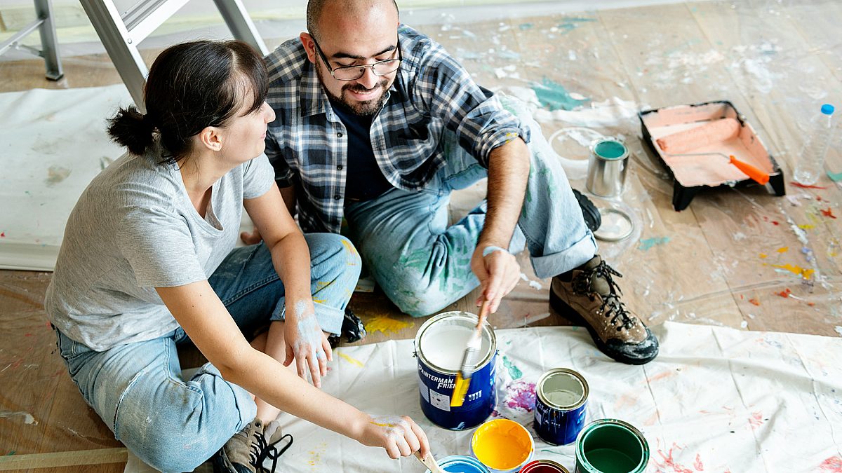Young couple sit on floor after painting house