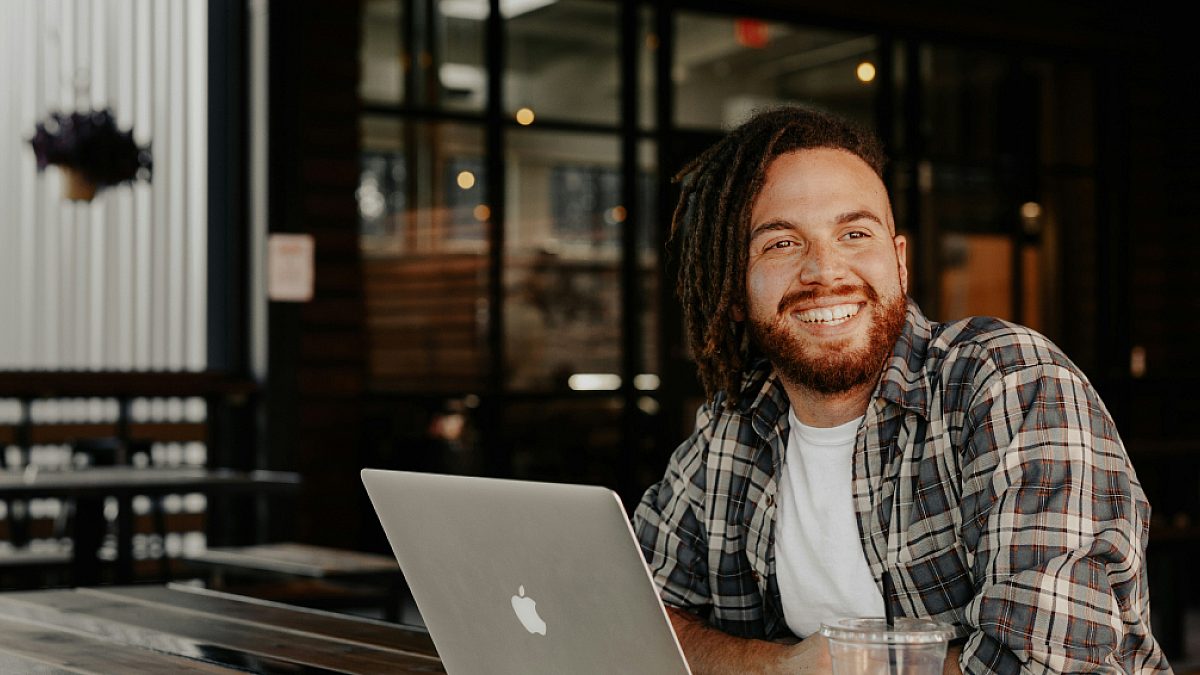 Man smiling and working on laptop